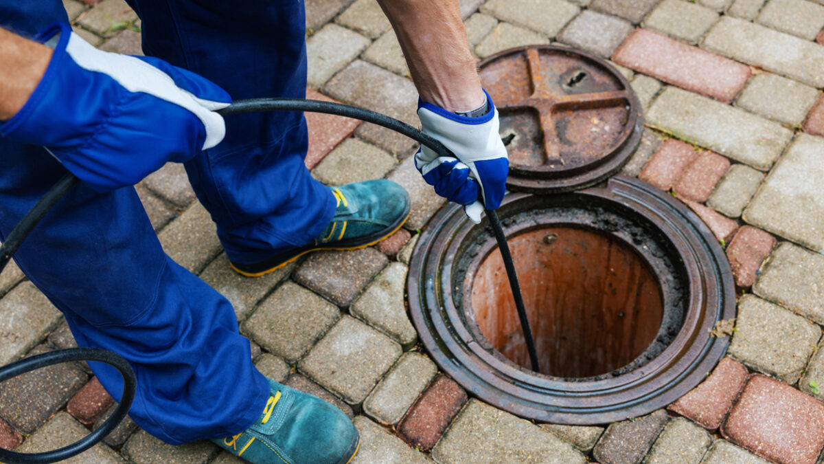 sewer cleaning service worker clean a clogged drainage with hydro jetting