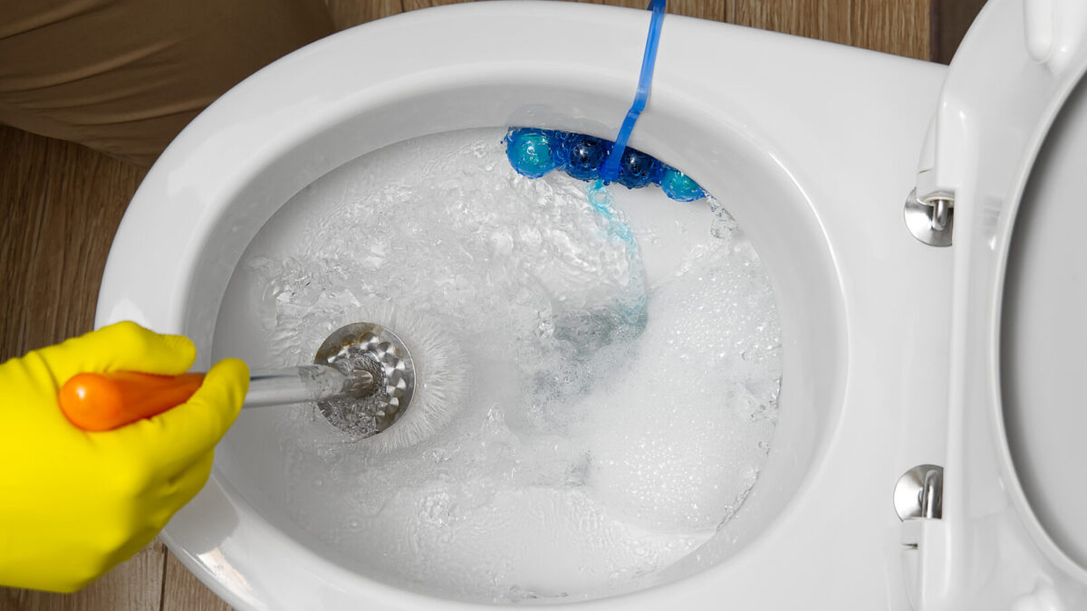 Man cleaning overflowing broken toilet. clogged toilet.